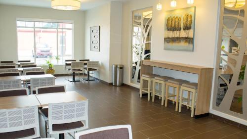 a dining room with tables and chairs and a fireplace at Microtel Inn & Suites by Wyndham - Penn Yan in Penn Yan