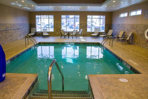 a swimming pool with chairs and tables in a building at Microtel Inn & Suites by Wyndham - Penn Yan in Penn Yan