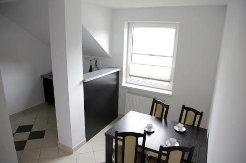 a dining room with a table and chairs and a window at Noclegi Prestige in Nowy Sącz