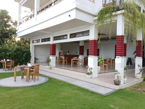 a building with tables and chairs in a yard at Hotel Genggong in Candidasa
