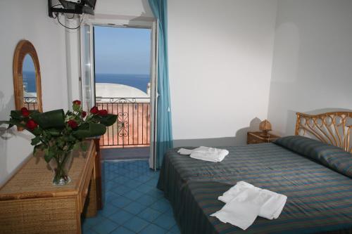 Habitación de hotel con cama y balcón en Affittacamere Via Muraglione, en Ventotene