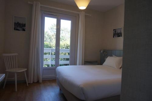 a bedroom with a bed and a large window at La Frégate in Cap-Ferret