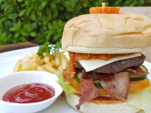 a sandwich and french fries on a plate with ketchup at Hotel Genggong in Candidasa
