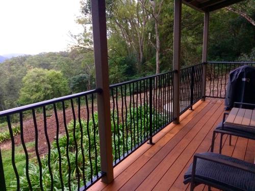 a screened in porch with a view of the mountains at Maleny Luxury Cottages in Maleny
