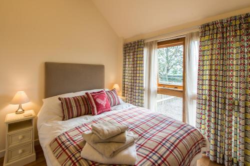 ein Schlafzimmer mit einem Bett und einem großen Fenster in der Unterkunft Cart Shed Cottage in Newport