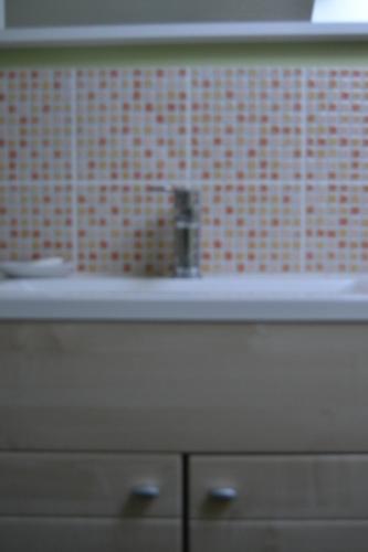 La salle de bains est pourvue d'un lavabo et d'un mur en carrelage rouge. dans l'établissement The peaceful countryside corner, à Mazé