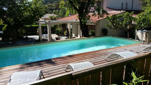 - une piscine sur une terrasse en bois avec des chaises dans l'établissement Le Clos du Loup, à La Colle-sur-Loup