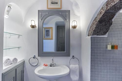 a bathroom with a sink and a mirror at Nautilus Villa in Firostefani