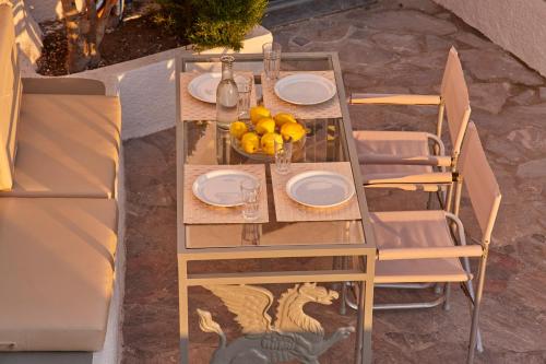 a table with plates and a bowl of fruit on it at Nautilus Villa in Firostefani