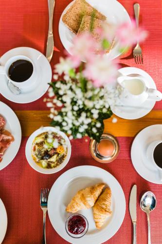una mesa con platos de comida en una mesa roja en Hotel Villa Marburg im Park, en Heigenbrücken