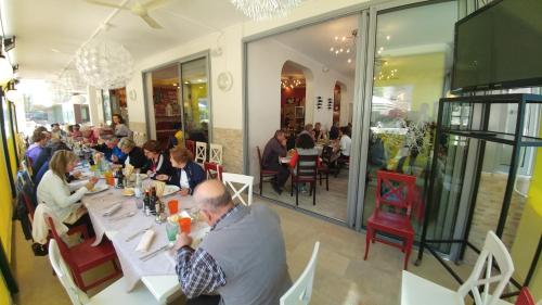 a group of people sitting at tables in a restaurant at Hotel Milano 3S in Bibione