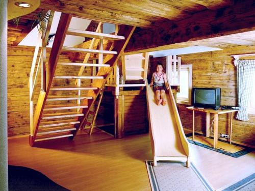 a woman is standing on a slide in a room at Lindlhof Fam. Taferner in Sankt Andrä