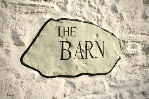 a sign that says the barn on a brick wall at The Barn in Monk Fryston