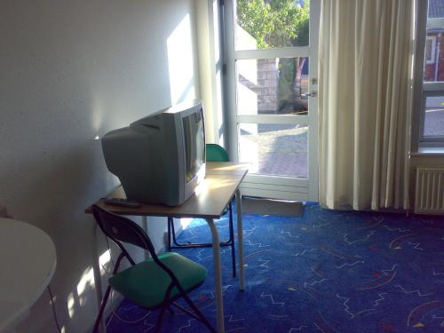 a television sitting on a table in front of a window at Hotel Gedser Apartments in Gedser