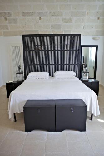 a bedroom with a large bed with a black headboard at Masseria Montelauro in Otranto