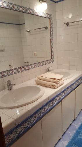 a white bathroom with a sink and a mirror at La Casa Degli Ospiti in Naples