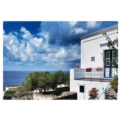 a white building with a balcony overlooking the ocean at Luna Rossa in Ginostra