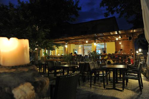 restauracja ze stołami i krzesłami w nocy w obiekcie Estelle Hotel w mieście Gerakini