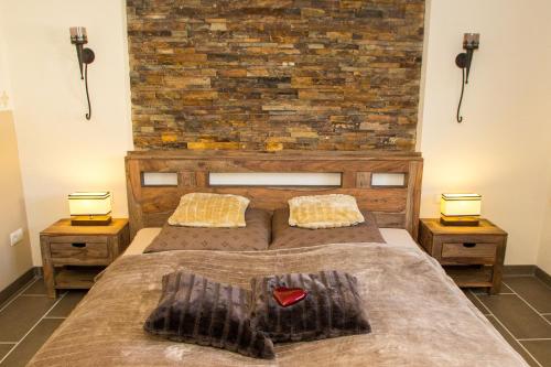 a bedroom with a large bed with a brick wall at Wildnisresidenz am Nationalpark in Lindberg