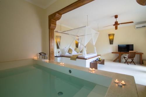 a living room with a swimming pool and a villa at Fruit & Spice Wellness Resort Zanzibar in Kizimkazi