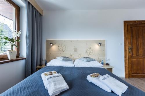 a bedroom with two towels on a blue bed at Willa Baciarka-basen, sauny i jacuzzi in Kościelisko