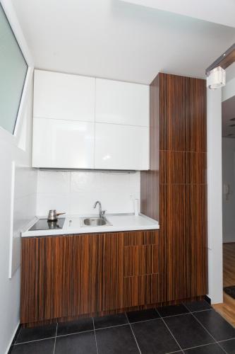 una cucina con lavello e mobili in legno di Apartment Matoseva a Belgrado