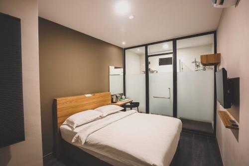 a bedroom with a large bed with white sheets at V3 Hotel & Residence Seri Alam in Pasir Gudang