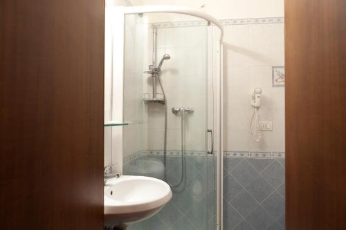 uma casa de banho com um chuveiro e um lavatório. em Hotel Porziuncola em Assis