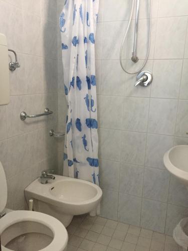 łazienka z toaletą i zasłoną prysznicową w obiekcie Albergo Maria Luisa w Rimini