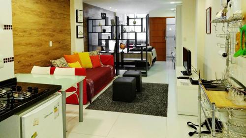 sala de estar con sofá rojo y cocina en Flat Felipe de Oliveira, en Río de Janeiro
