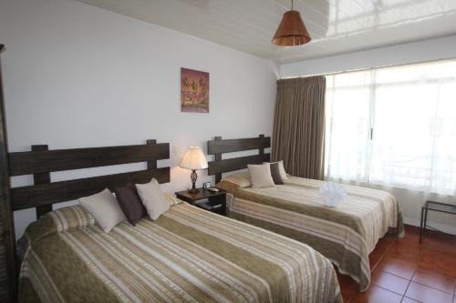 Cama ou camas em um quarto em Hotel Arenal by Regina