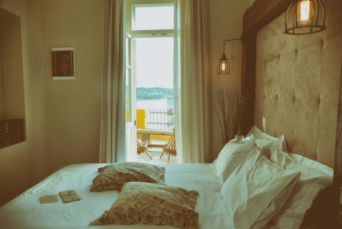 a bedroom with a bed and a window with a view at 1901 Hermoupolis in Ermoupoli