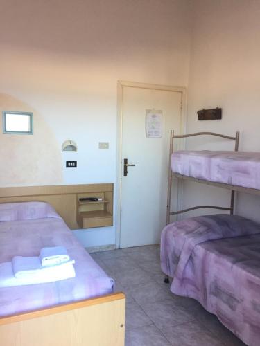 um quarto com 2 beliches e uma porta em Albergo Maria Luisa em Rimini