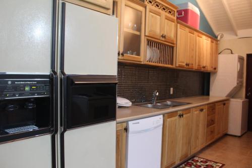 a kitchen with wooden cabinets and a refrigerator at Driftwood 85 in Canaan