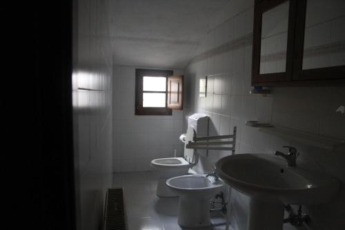 a bathroom with a toilet and a sink and a window at Casa Vacanze Good Buy in San Gimignano