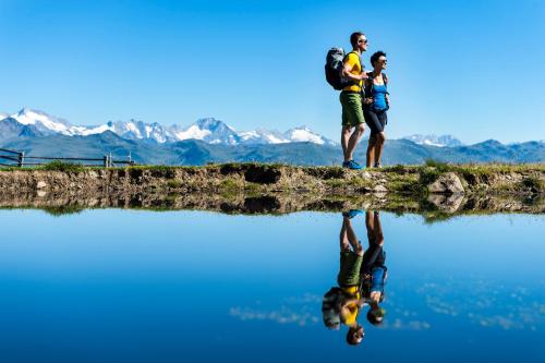 a man and a child standing on top of a body of water at Hotel Garni Hochgruber in Brunico