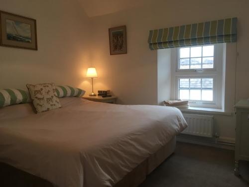 a bedroom with a white bed and two windows at The Kestrel B&B in Crickhowell