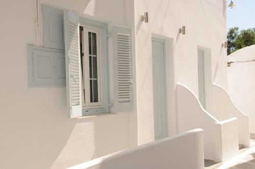 a white building with a window and stairs at Starlight Luxury Studios in Mýkonos City