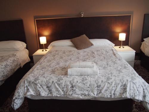 a bedroom with a large bed with a white towel on it at Kingswood Hotel in Maidenhead