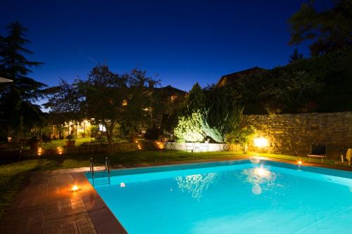 a swimming pool in a backyard at night at Borgo La Capraia in Castelfranco di Sopra