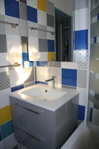 a bathroom with a sink and a mirror at Un petit coin de paradis in Barbâtre