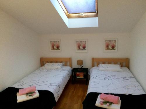 two beds in a room with a window at Apartments Brčić in Kaštela