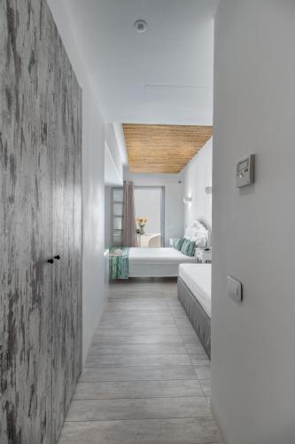 a bedroom with two beds and a bathroom in the background at Thomais Studios in Naxos Chora