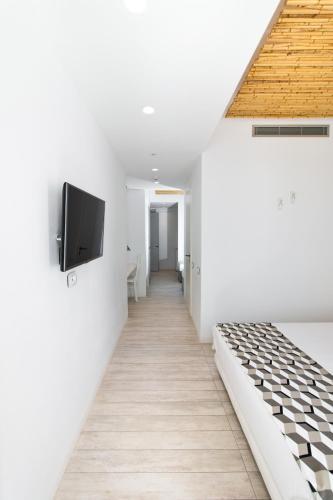 a hallway with white walls and a flat screen tv on a wall at Thomais Studios in Naxos Chora