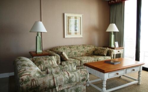 a living room with a couch, coffee table and a lamp at Club Regency at Regency Towers in Myrtle Beach