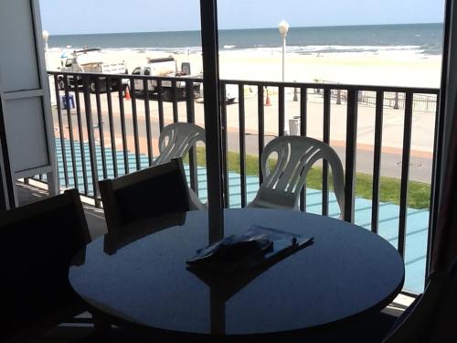 a table and chairs on a balcony with the beach at The Schooner Inn in Virginia Beach