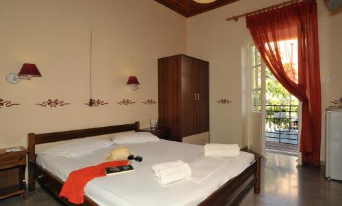 a bedroom with a bed with a red towel on it at Guesthouse Corali in Hydra