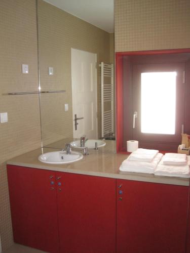 baño con lavabo y armario rojo en Casa da Torre en Sobrosa