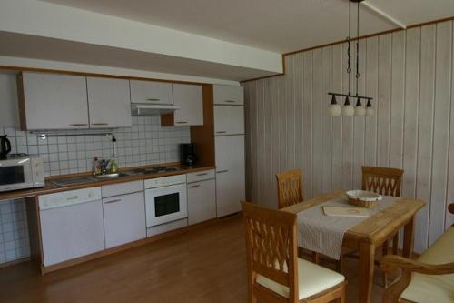 a kitchen with a table and a kitchen with white cabinets at Haflingerhof - Oberjoch in Bad Hindelang