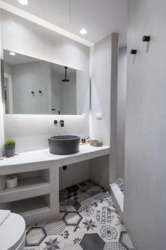a white bathroom with a sink and a mirror at Thomais Studios in Naxos Chora